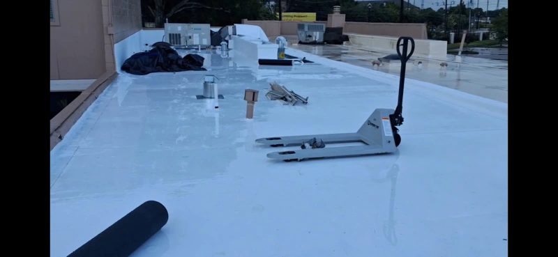 Freshly-coated flat commercial roof with materials staged for install